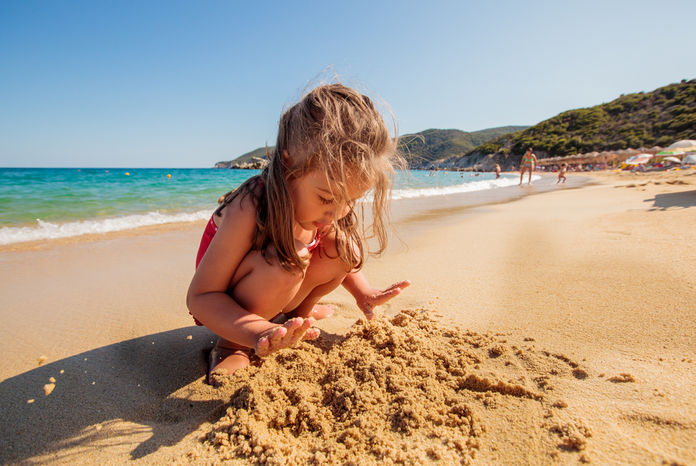 holcicka si hraje na pisecne plazi na Malloce