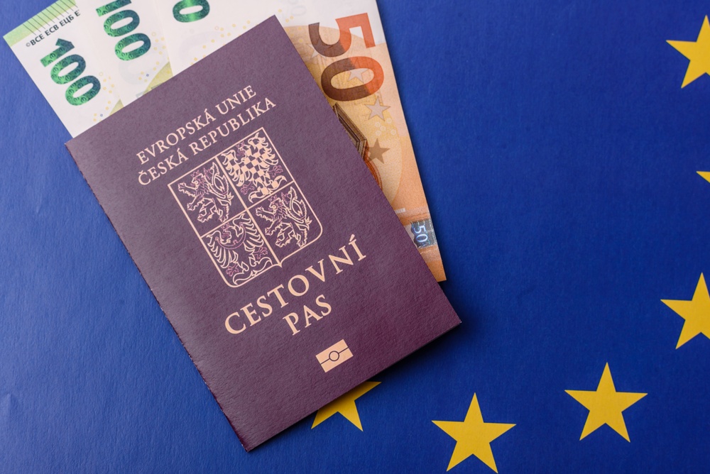 Český cestovní pas s euro bankovkami na pozadí vlajky EU