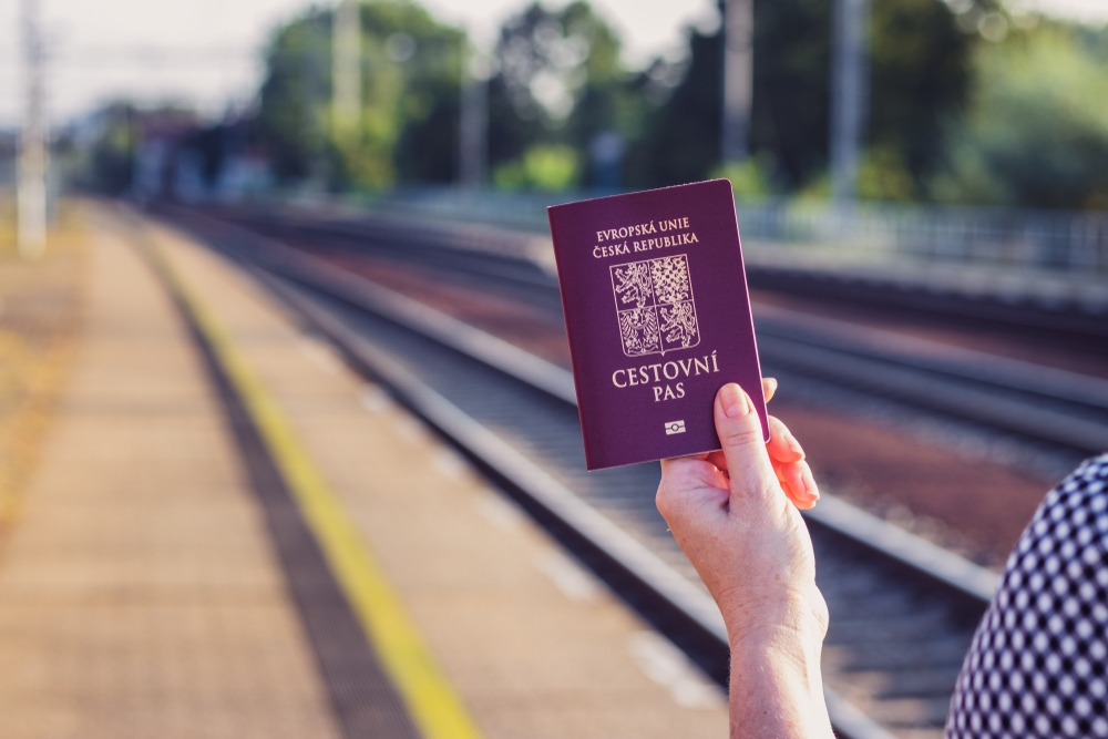 Český cestovní pas v ruce ženy na vlakové stanici