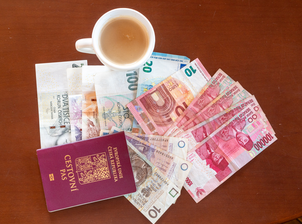 Cestovní pas, bankovky různých měn a šálek kávy