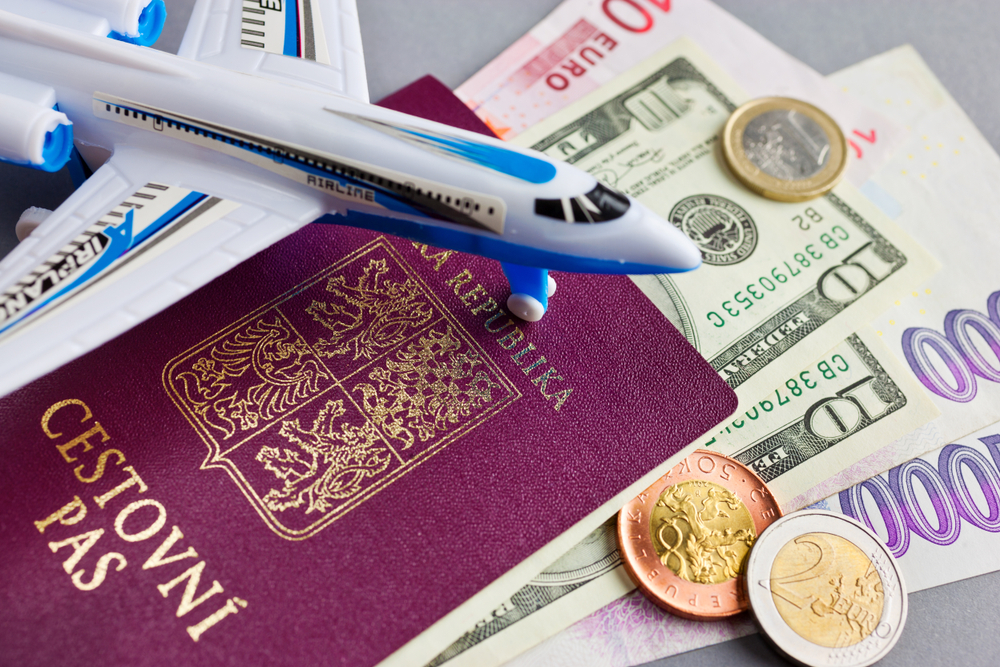 Cestovní pas ČR s malým plastovým letadlem, dolary, eury a korunami
