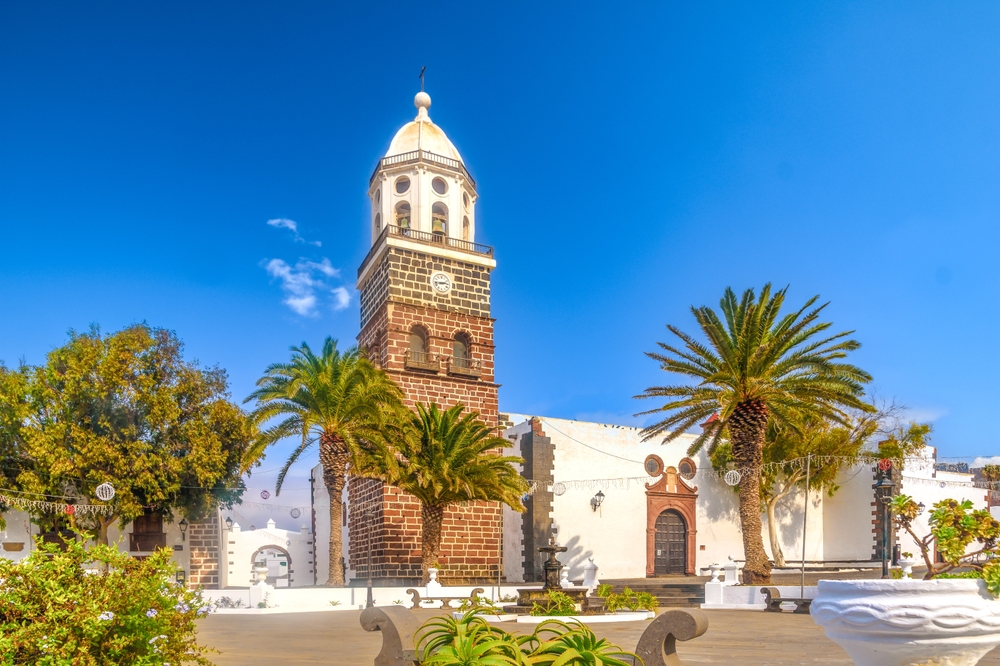 Dovolená na Lanzarote – co vidět během pobytu na ostrově? Atrakce a zajímavosti 7 Historická budova ve městě Teguise obklopená palmami a keříky