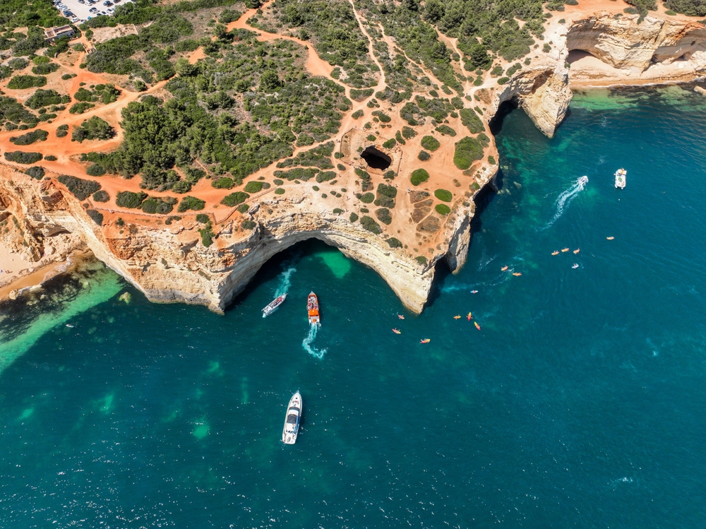 Lodě a kajaky u vchodu do jeskyně Benagil na pobřeží Algarve