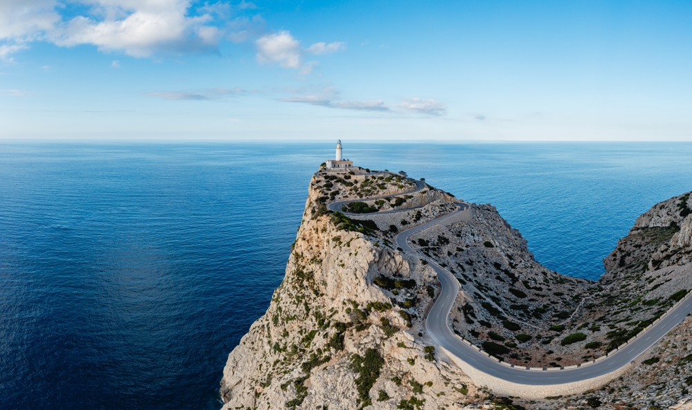 Maják Far de Formentor na Mallorce s klikatou silnicí a modrým mořem