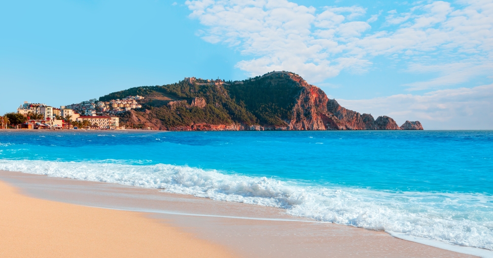 Nádherná Kleopatřina pláž v Alanyi s jemným pískem a zářivě modrou vodou