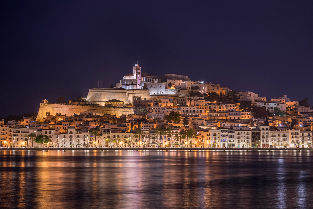 Pohled na Ibizu v noci s osvětlením a zářivým mořem