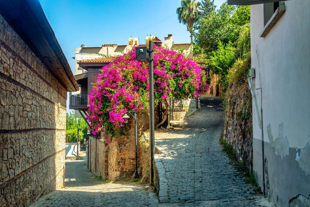 Úzká malebná ulička s květinami kousek od Alanyjské pevnosti v Turecku