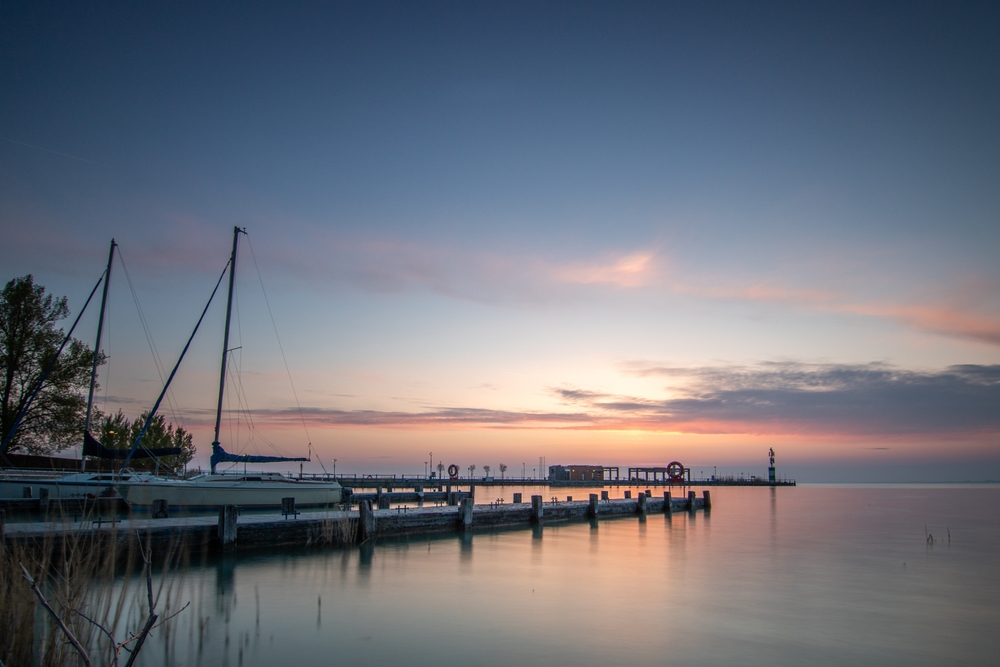 Východ slunce na jezerem Balaton v Maďarsku s molem