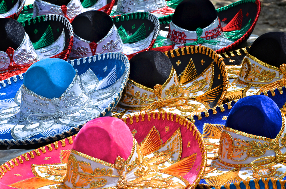 Kloubouky sombrero v různých barvách na trhu v Mexiku