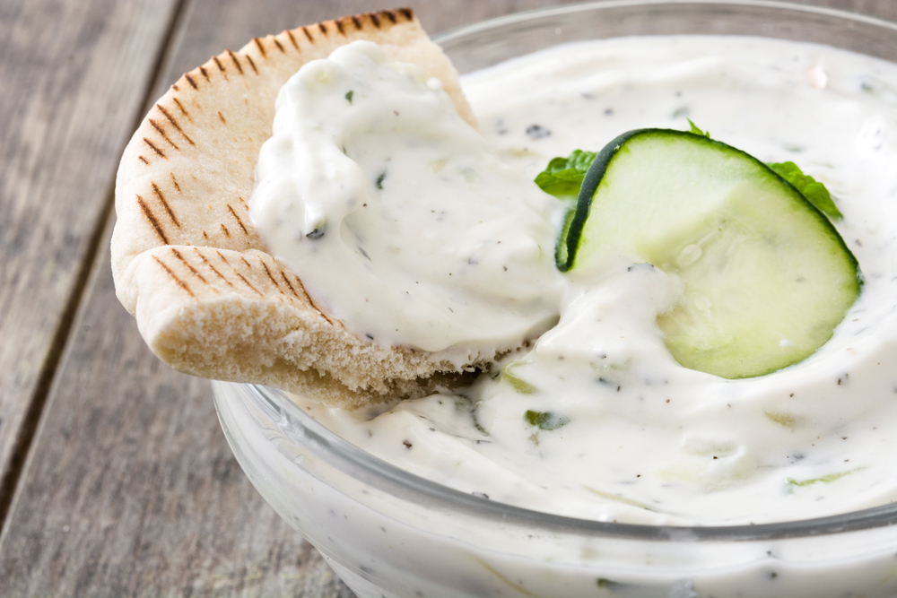 Co jíst na Krétě? Pokrmy, které musíte ochutnat 5 Tzatziki a pita chléb na rustikálním dřevěném stole