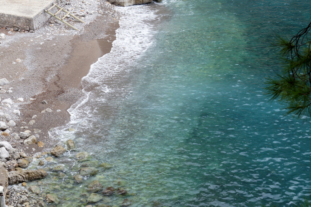 Divoký přístav Port de Sa Calobra na Mallorce s kameny, vlnami a mořem