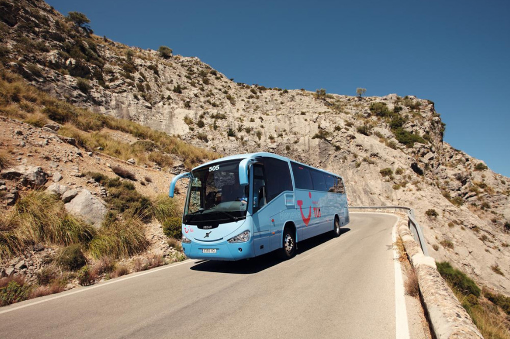 10 věcí, které jste o TUI možná nevěděli – poznejte světovou cestovní kancelář! 4 Autobus TUI na silnici mezi útesy a horami