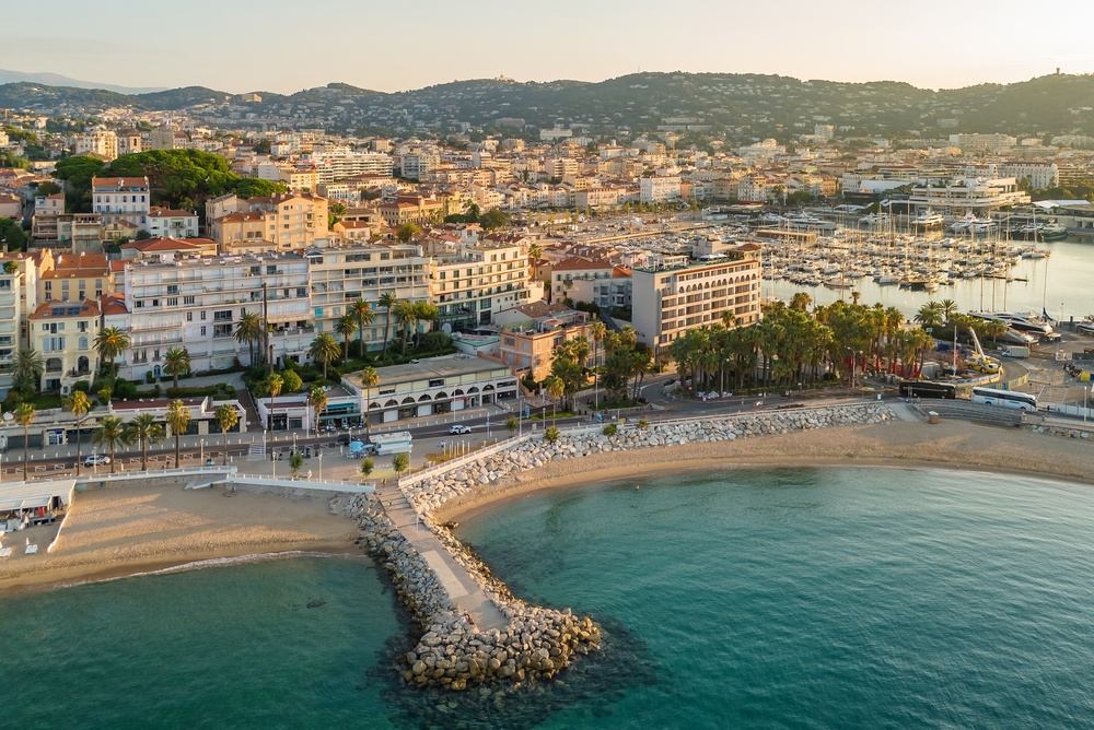 Francouzská riviéra – třídenní itinerář na perfektní eurovíkend 5 Letecký pohled na krásnou pláž v Cannes při východu slunce s luxusními hotely a obytnými budovami