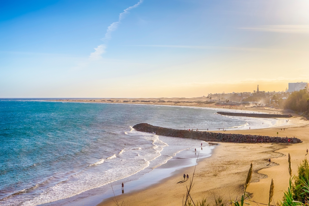 Maspalomas – atrakce, duny a další zajímavosti na Gran Canarii 4 Malebný západ slunce na pláži Playa del Ingles v Maspalomas s písečnými dunami a skalami na břehu na Gran Canarii ve Španělsku